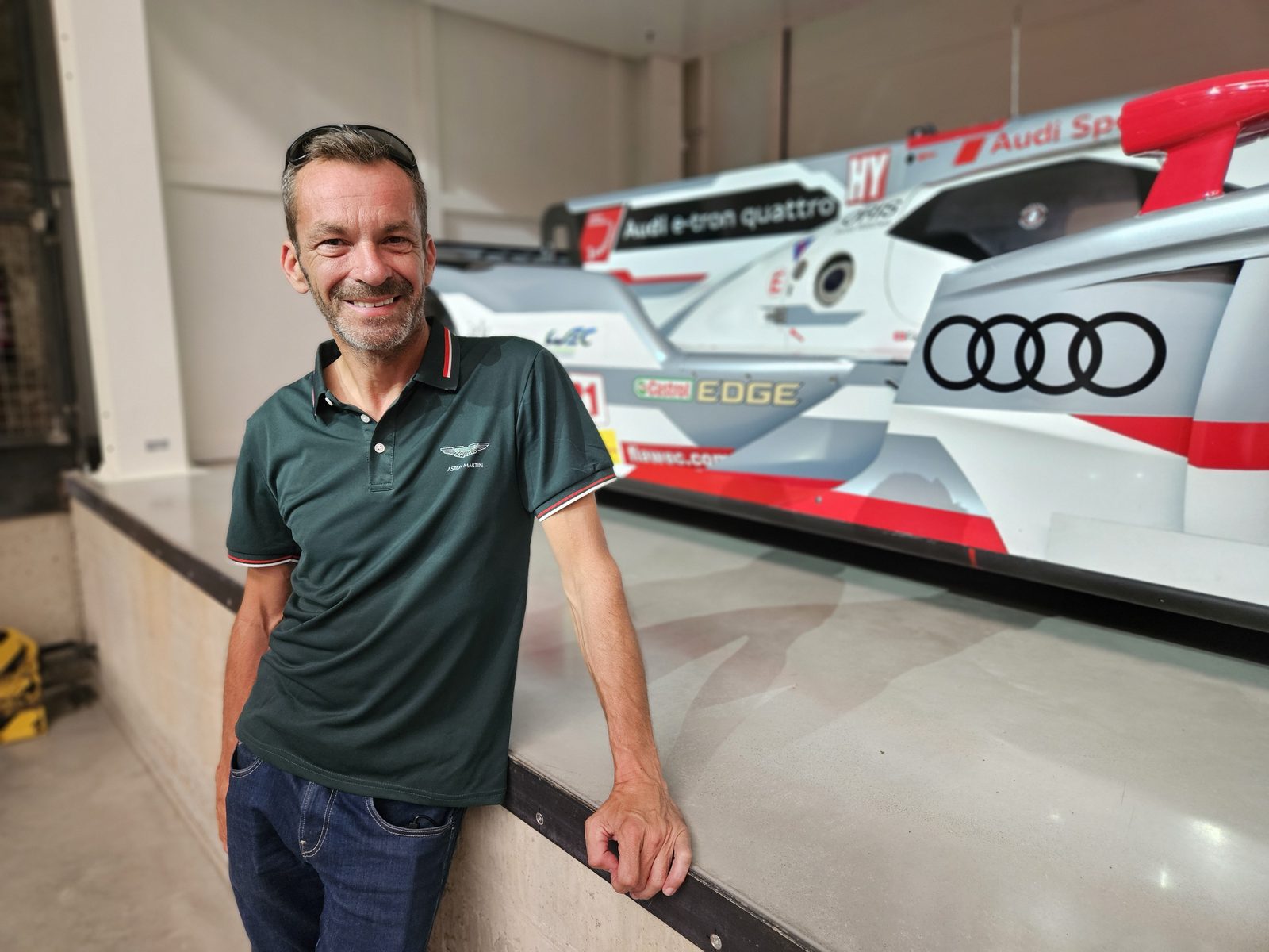 Harry lächelnd vor einem Le-Mans-Rennwagen